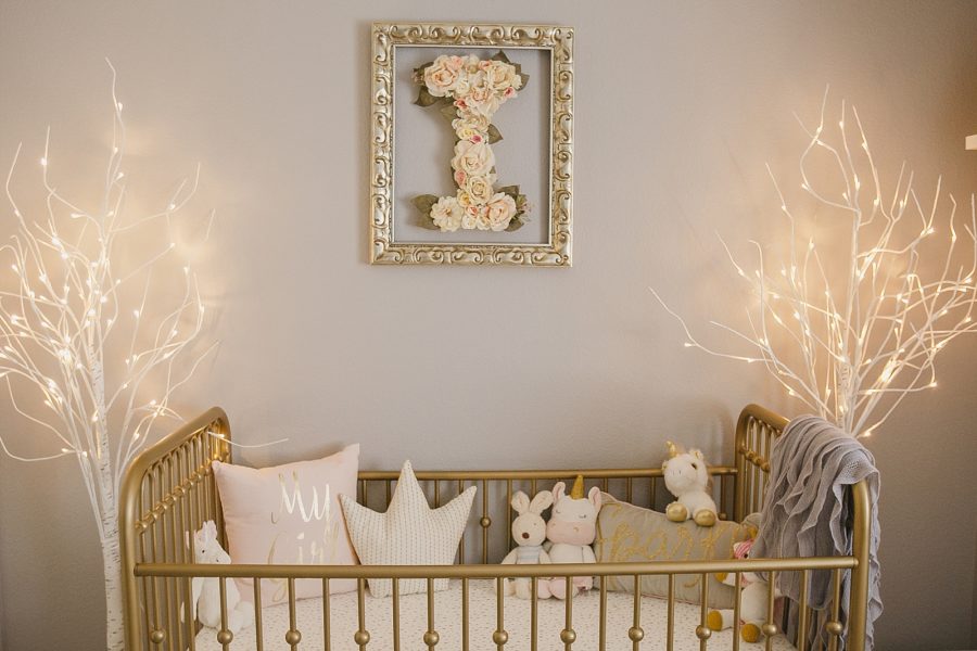Gold crib with floral letter above it
