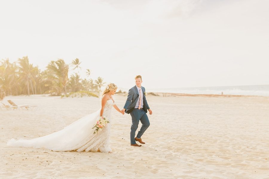 bride and groom walking on beach at Hard Rock Punta Cana