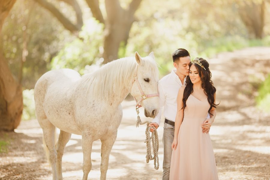 Whimsical engagement photo of couple with horse in the woods