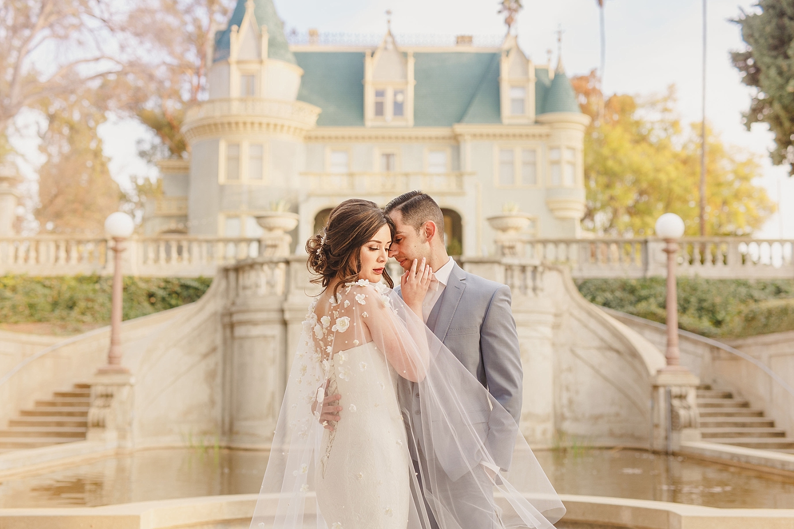 Romantic wedding photo of bride and groom in front of Kimberly Crest House in Redlands, CA