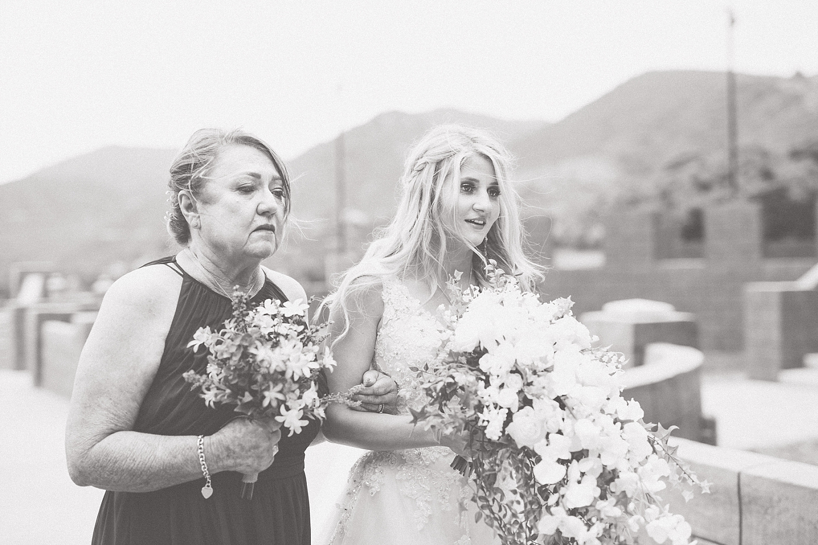 mother and bride walk down the isle