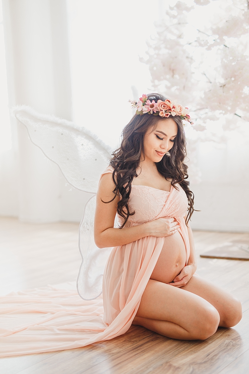 Fairytale maternity photos with flower crown and fairy wings